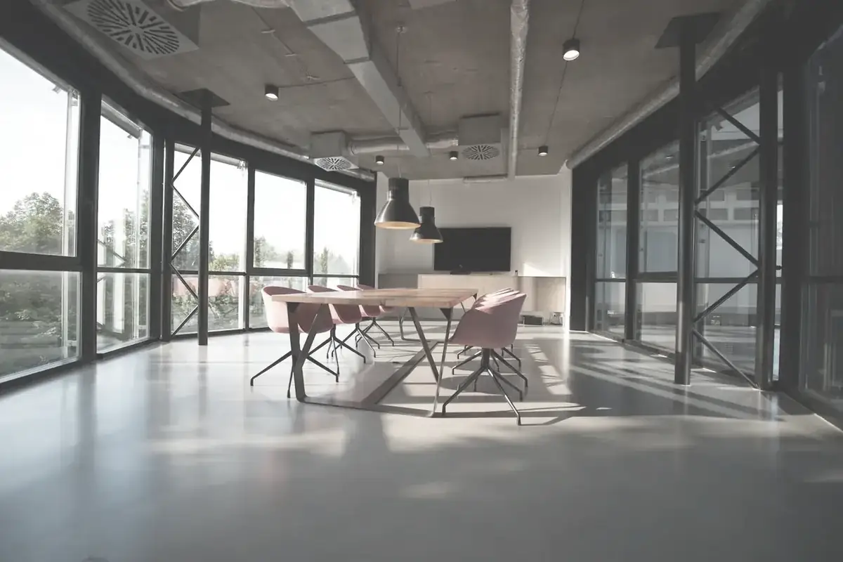 A boardroom table beside full-height windows