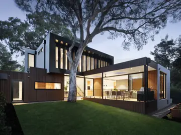 A contemporary house lit from within at dusk
